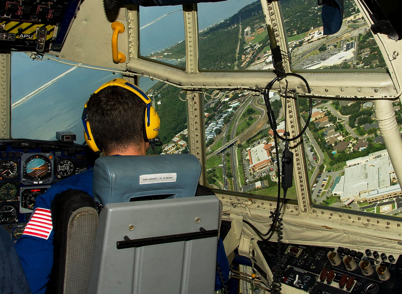 View of Pensacola neighborhoods and coastline from the flight deck of a military aircraft