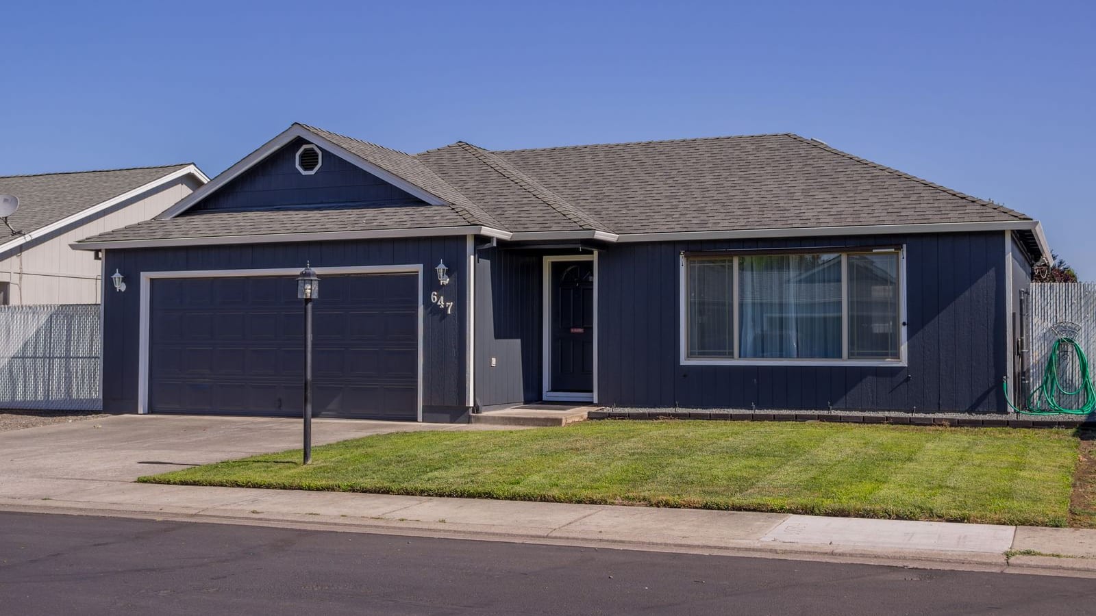A tidy single-story ranch home with a two-car garage and front lawn
