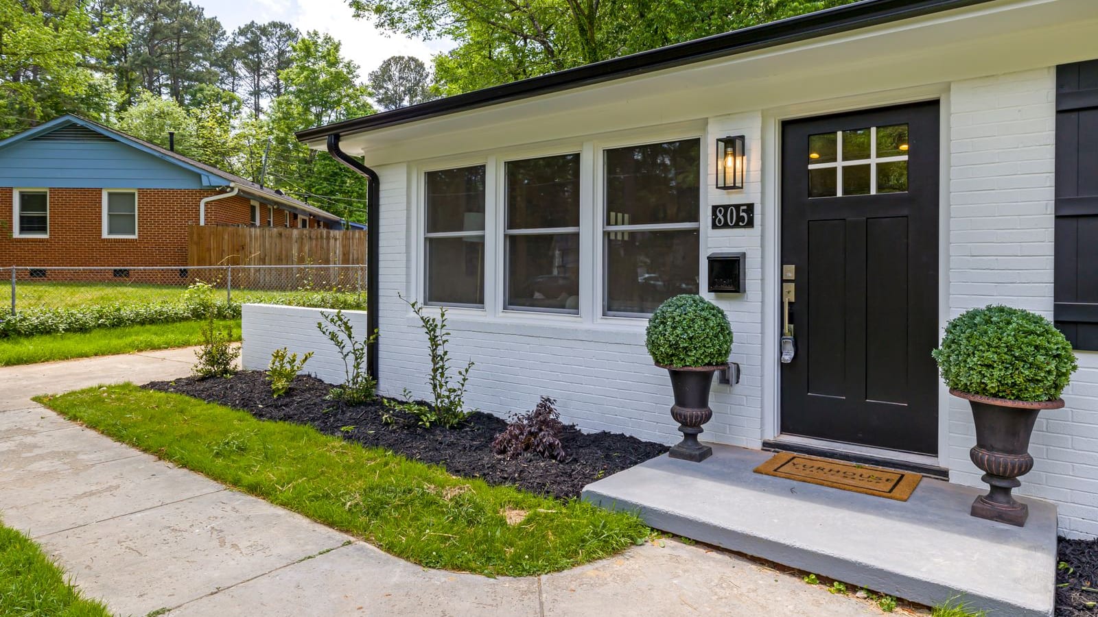 Front exterior of a modern single-family home with landscaped front yard and a welcoming entrance under bright natural daylight